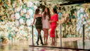3 women standing next to a room of yellow and green flowers part of the exhibition Bloomtanica in Genesis House New York, made in collaboration with Blackspace GmbH and Jeff Leatham.
